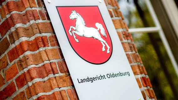 Ein Schild mit dem niedersächsischen Landeswappen hängt am Eingang zum Landgericht Oldenburg. © picture alliance/dpa Foto: Hauke-Christian Dittrich