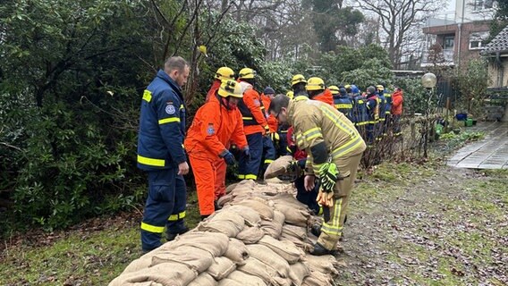 In Oldenburg Bümmerstede sichern zahlreiche Einsatzkräfte mit Sandsäcken ein Haus. © NDR Foto: Olaf Kretschmer