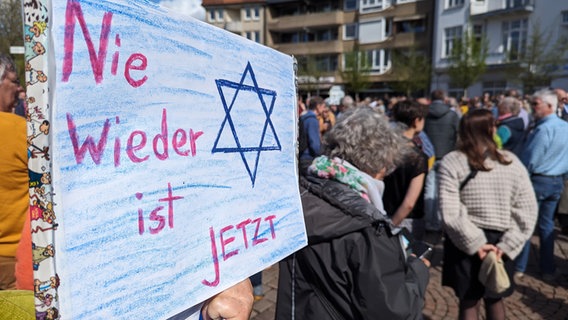 Auf einer Solidaritätsdemo in Oldenburg ist ein Schild mit einem Davidstern und dem Text "Nie wieder ist jetzt" zu sehen. © NDR Foto: Sebastian Duden
