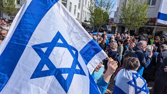 Auf einer Solidaritätsdemo in Oldenburg wird eine Flagge von Israel hochgehalten. © NDR Foto: Sebastian Duden