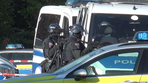 Einsatzkräfte der Polizei stehen in einer Straße in Oldenburg, nachdem ein Mann eine Frau bedroht haben soll. © Nord-West-Media TV 