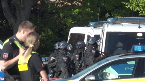 Einsatzkräfte der Polizei stehen in einer Straße in Oldenburg, nachdem ein Mann eine Frau bedroht haben soll. © Nord-West-Media TV 