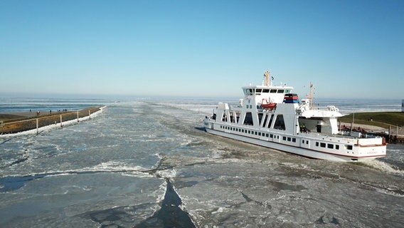 Ein Schiff fährt in Ostfriesland durch Eisschollen aufs Meer. © NDR 