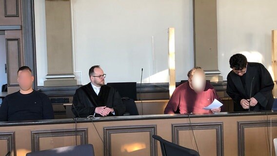 Die Angeklagten einer Geiselnahme in Oyten sitzen vor dem Landgericht in Verden und beraten sich mit ihren Anwälten. © NDR Foto: Maren Momsen