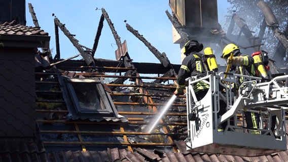 Einsatzkräfte der Feuerwehr löschen ein Einfamilienhaus in Papenburg von einer Drehleiter aus. © Nord-West-Media TV 