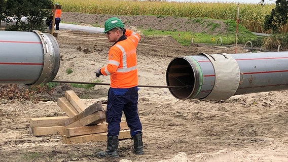 Ein Mann überwacht das Ansetzen zweier Pipelinerohre © NDR Foto: Jutta Przygoda