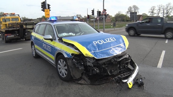 Ein Streifenwagen steht nach einem Unfall mit zerstörter Front auf einer Straße. © Nord-West-Media TV 