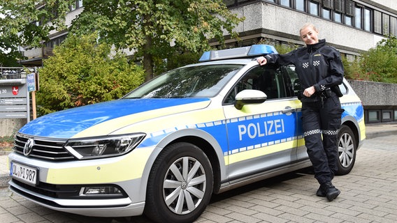 Ein Polizistin in norwegischer Polizeiuniform lehnt an einem deutschen Streifenwagen. © Polizeiinspektion Oldenburg-Stadt / Ammerland 