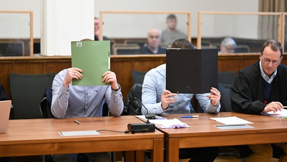 Zwei angeklagte Polizisten sitzen in einem Gerichtssaal in Aurich. © dpa Foto: Lars Penning
