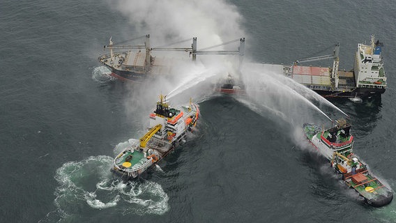 Der Notfall-Hochseeschlepper "Nordic" und das Mehrzweckschiff "Neuwerk" schießen Wasser auf den qualmenden Frachter "Purple Beach". © Havariekommando Cuxhaven Foto: Havariekommando Cuxhaven