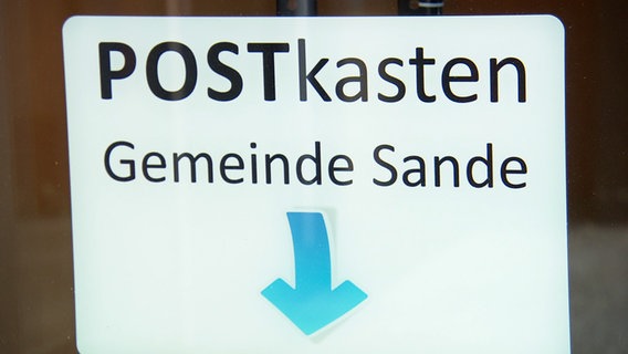 Ein Schild weist auf den Postkasten der Gemeinde Sande hin. © NDR 