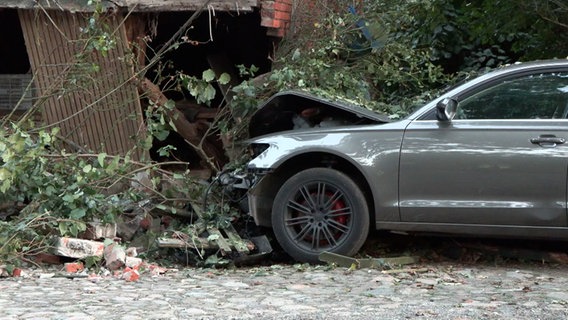 Ein beschädigtes Auto steht nach einem Unfall in Sandhatten an einer Hauswand. © Nord-West-Media TV 
