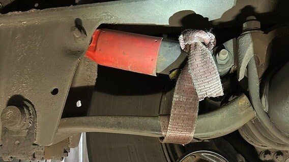 Eine Lkw-Achse ist provisorisch mit einem Spanngurt fixiert. Eine Lkw-Achse ist provisorisch mit einem Spanngurt fixiert. © Polizeiinspektion Emsland/Grafschaft Bentheim