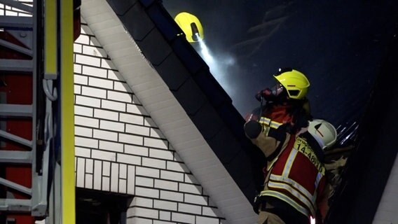 Einsatzkräfte löschen einen Brand einer Sauna in einem Dachstuhl. © TeleNewsNetwork 