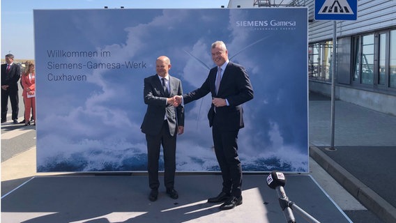 Bundeskanzler Olaf Scholz (r., SPD) und der Chef von Siemens Games, Jochen Eickholt reichen sich bei einem Fototermin diue Hand. © NDR Foto: Jörn Pietschke