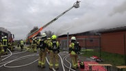 Einsatzkräfte der Feuerwehr löschen einen brennenden Schweinestall. © Nord-West-Media TV 