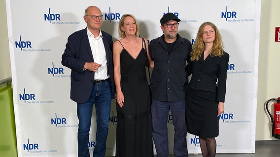 NDR-Intendant Joachim Knuth steht zusammen mit Regisseur Bjarne Mädel und Darstellerinnen bei der Premiere des Films "Sörensen fängt Feuer". © NDR Foto: Marlene Santel
