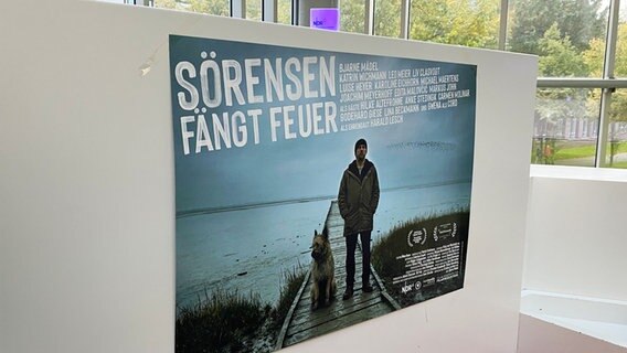 Das Plakat für den Film "Sörensen fängt Feuer" hängt bei der Premiere in einem Kino-Foyer. © NDR Foto: Marlene Santel