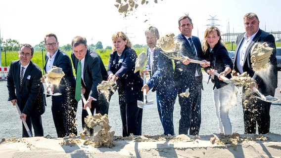 Greg Hands (3.v.l.-r), Staatsminister im Ministerium des Königreichs Großbritannien für Wirtschaft und Handel Julia Prescot, Vorsitzende von Neuconnect, Robert Habeck (Bündnis 90/Die Grünen), Bundesminister für Wirtschaft und Klimaschutz, und Olaf Lies (SPD), Wirtschaftsminister von Niedersachsen, bei einem symbolischen Spatenstich am zukünftigen Anlandepunkt der neuen Stromleitung Neuconnect. © picture alliance Foto: Sina Schuldt