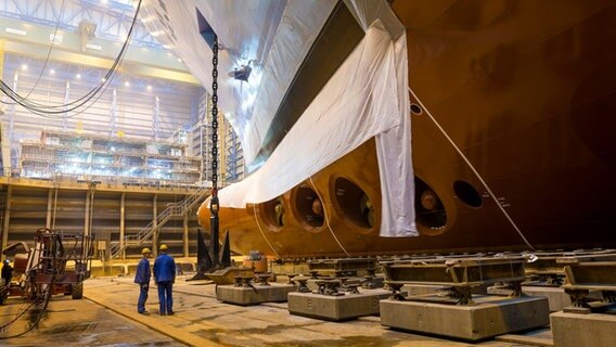 Zwei Mitarbeiter der Meyer Werft stehen  vor den Schiffsschrauben der Spectrum of the Seas. © Meyer Werft 