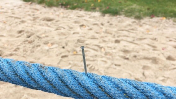 Ein Nagel ragt aus einem Seil auf einem Spielplatz. © Polizeiinspektion Oldenburg-Stadt 