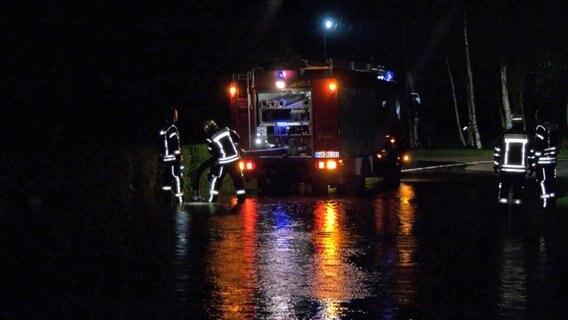 Einsatzkräfte der Feuerwehr pumpen Wasser von einer überfluteten Straße ab. Einsatzkräfte der Feuerwehr pumpen Wasser von einer überfluteten Straße ab. © NonstopNews