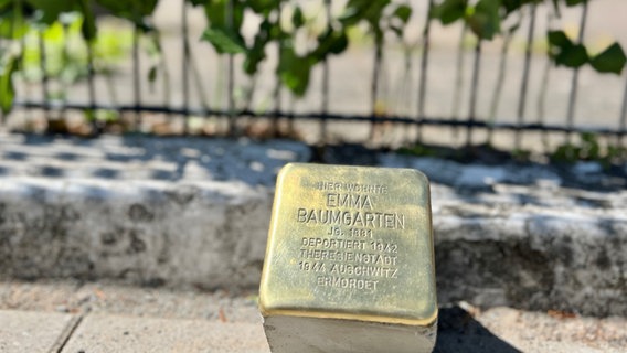 Ein goldener Stein mit einer Inschrift, die an die Jüdin Emma Baumgarten erinnert. © Stadt Achim) 