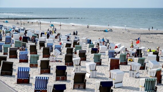 Zahlreiche Strandkörbe stehen bei sonnigem Wetter am Strand der Insel Wangerooge. © picture alliance Foto: Hauke-Christian Dittrich