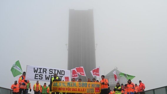 Protestierende stehen vor der hochgeklappten Jann-Berghaus-Brücke. © Lars Penning/dpa Foto: Lars Penning