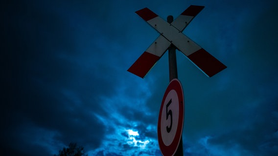 Ein Andreaskreuz-Schild vor bewölktem Himmel am frühen Morgen während des Sturmtiefs "Ignatz". © dpa-Bildfunk Foto: Mohssen Assanimoghaddam