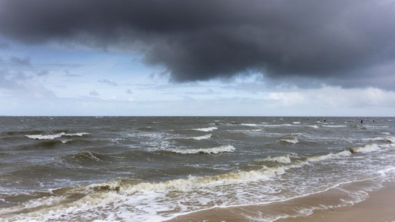 Am Strand von Cuxhaven ziehen dunkle Wolken über die aufgewühlte Nordsee. © picture alliance / imageBROKER | Wilfried Wirth Foto: Wilfried Wirth