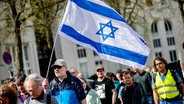 Ein Mann mit einer Israel-Flagge bei einer Solidaritäts-Kundgebung für die Jüdische Gemeinde in Oldenburg © dpa-Bildfunk Foto: Hauke-Christian Dittrich