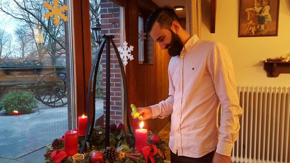 Basel Taifour zündet die Kerzen am Adventskranz an. © NDR Foto: privat