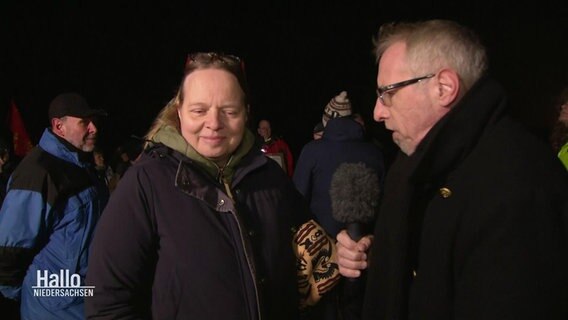 Reporter Olaf Kretschmer spricht in Hooksiel mit protestierenden Umweltschützern. © NDR 