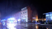 Einsatzkräfte der Feuerwehr stehen vor einem Mehrfamilienhaus in Twistringen. © Nord-West-Media TV 
