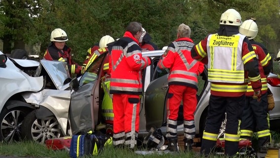 Rettungskräfte stehen an einem Unfallauto. © Nord-West-Media TV 