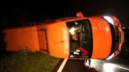 Ein Begleitfahrzeug eines Schwerlasttransporter liegt auf der Seite nach einem Unfall. © tv7news 