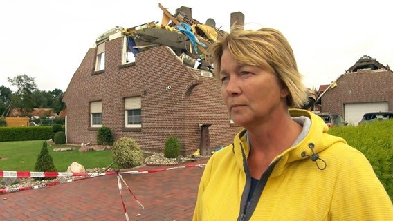 Monika Graver steht vor ihrem zerstörten Haus. © NDR 