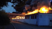 Dichter, dunkler Rauch quillt aus dem Dach einer Porzellanfabrik in Varel (Landkreis Friesland). © Nord-West-Media TV 