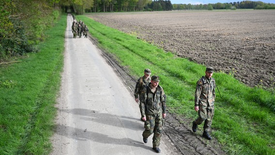 Soldaten der Bundeswehr gehen einen Waldweg entlang, nachdem sie ein Waldstück nach dem vermissten Arian aus Bremervörde abgesucht haben. © dpa Foto: Lars Penning