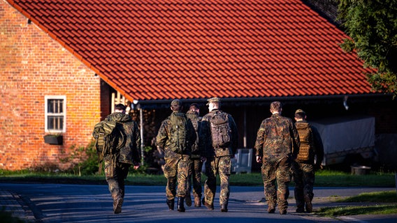Elm: Einsatzkräfte der Bundeswehr laufen durch den Wohnort des vermissten Jungen. © dpa-Bildfunk Foto: Sina Schuldt