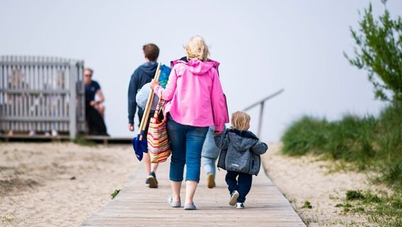 Touristen gehen im Urlaubsort Schillig an den Strand. © picture alliance / Kirchner-Media/Wedel 