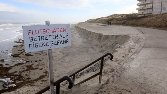 Ein Schild mit der Aufschrift "Flutschäden - Betreten auf eigene Gefahr" steht an der Strandpromenade von Wangerooge. © picture alliance/dpa/Peter Kuchenbuch-Hanken Foto: Peter Kuchenbuch-Hanken