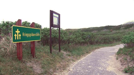 Ein Schild weist auf einer Kriegsgräberstätte auf Wangerooge hin. © NDR 