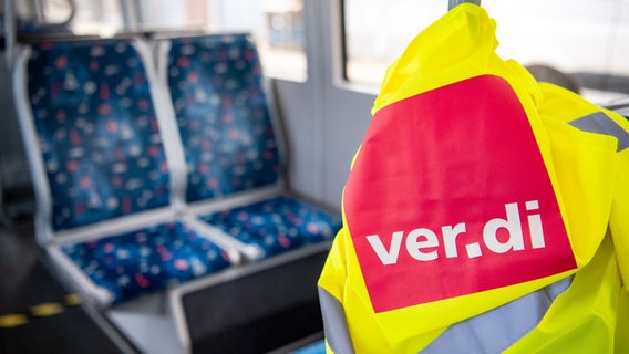 Eine Warnweste der Gewerkschaft Verdi liegt bei Warnstreiks in einem Bus. © picture alliance / dpa / Sina Schuldt Foto: Sina Schuldt