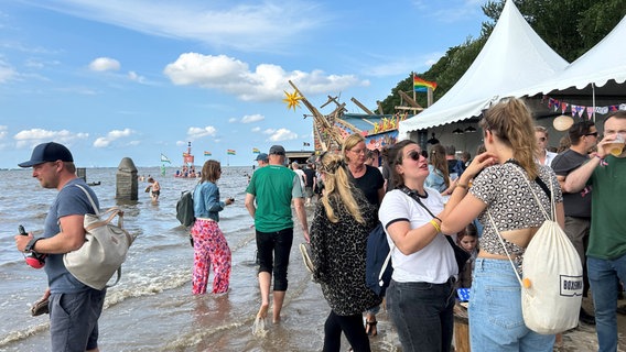 Besucher des Watt en Schlick Fests in Dangast stehen am Wasser. © NDR Foto: Olaf Kretschmer