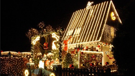 Tausende von Glühlampen erleuchten in Delmenhorst ein weihnachtlich geschmücktes Haus. © dpa-Bildfunk Foto: Sönke Möhl