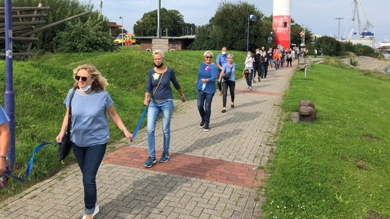 Demonstranten gegen die Weservertiefung bilden in Nordenham eine Menschenkette am Ufer der Weser. © NDR Foto: Jutta Przygoda