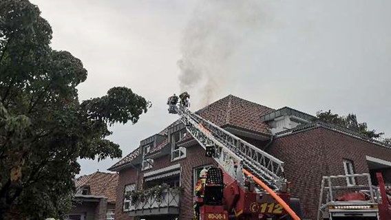 Einsatzkräfte der Feuerwehr löschen ein Mehrfamilienhaus in Westerstede von einer Drehleiter aus. © Polizeiinspektion Oldenburg-Stadt / Ammerland 