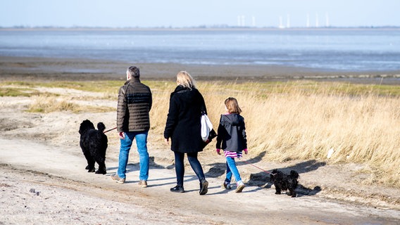 Eine Familie spaziert am Strand in Dangast. © dpa-Bildfunk Foto: Hauke-Christian Dittrich
